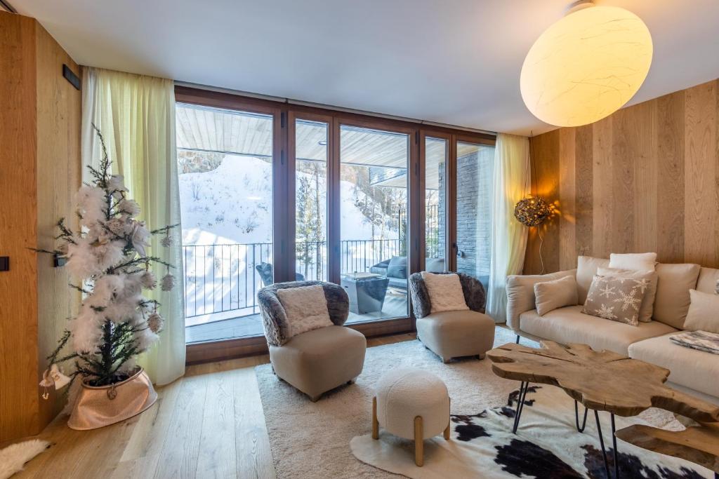 un soggiorno con divano, sedie e tavolo di Isard Homes by Select Rentals 8354 a El Tarter