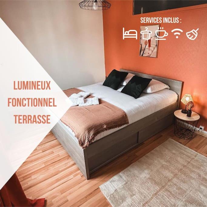 une chambre avec un lit avec un mur orange dans l'établissement Le Cosmic Bliss • Chic Urbain au cœur du Berry, à Châteauroux