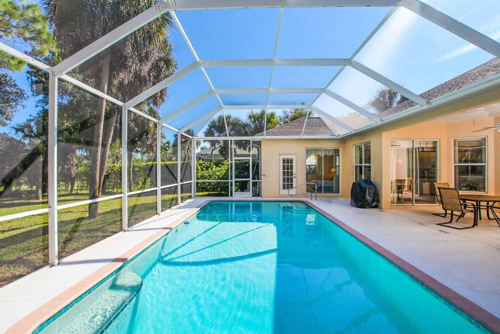 een huis met een zwembad met een glazen plafond bij Villa Manasota Hideaway in South Venice