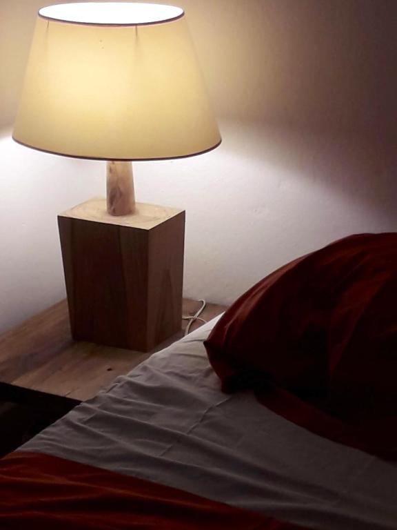 a lamp on a table next to a bed at Appartement d&#39;une chambre avec terrasse amenagee a Grand Bourg in Grand-Bourg