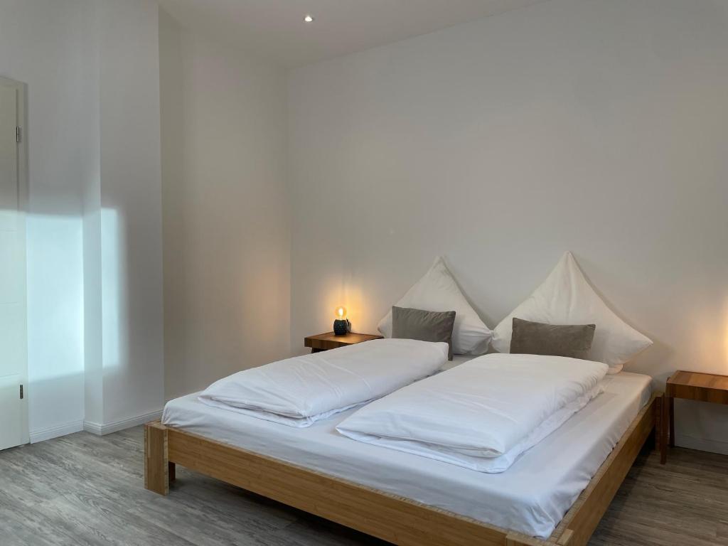 um quarto com uma cama com lençóis brancos e almofadas em SPLENDID I Unique Spacious Apartment em Hanôver