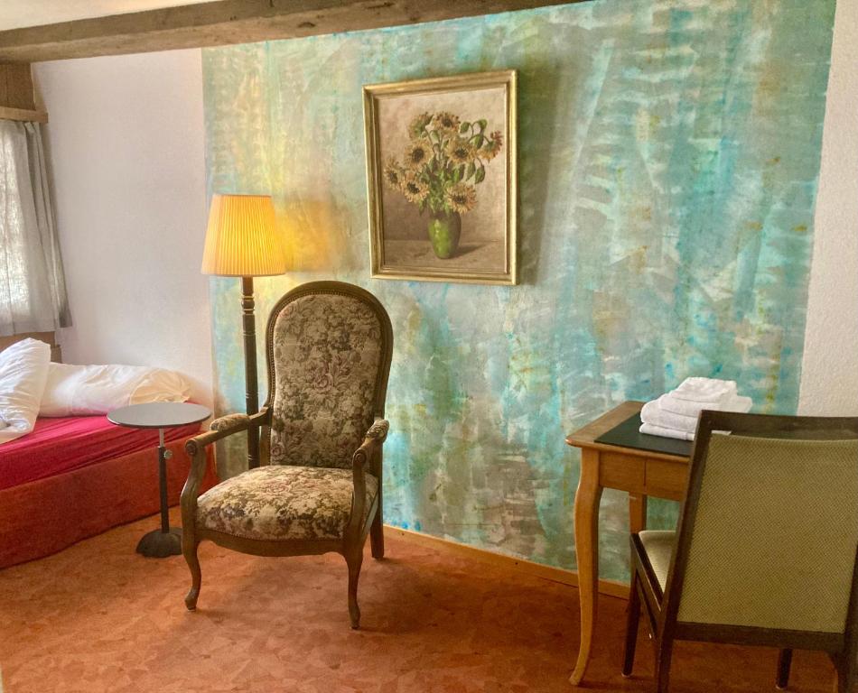 Pokój z krzesłem, łóżkiem i stołem w obiekcie FriendsHouse Appenzellerhof w mieście Speicher