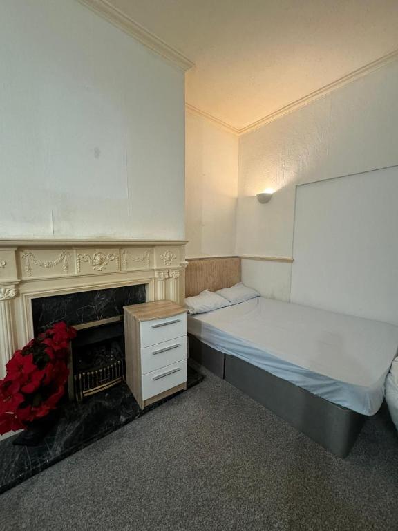 a small room with a bed and a fireplace at 316 Ripponden home in Moorside