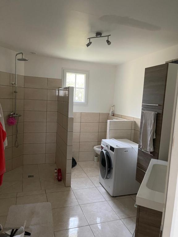 a bathroom with a washing machine and a sink at Maison spacieuse de Lila avec 3 places de parkings in Crèvecoeur-le-Grand