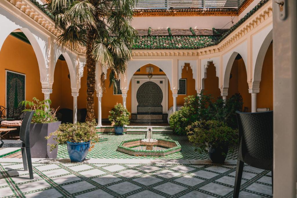 um pátio com uma fonte e palmeiras em Magnifique Riad avec patio extérieur em Vichy