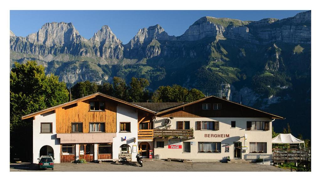 a large building with mountains in the background at Hotel Restaurant Bergheim in Flumserberg