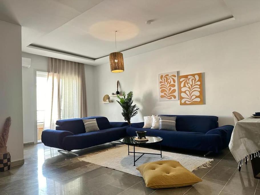 a living room with a blue couch and a table at Saf-Saf Apartement 1 in La Marsa
