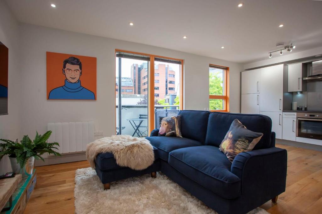 a living room with a blue couch and a kitchen at higgihaus Cabot Mews #38 Fantastic Central Location in Bristol