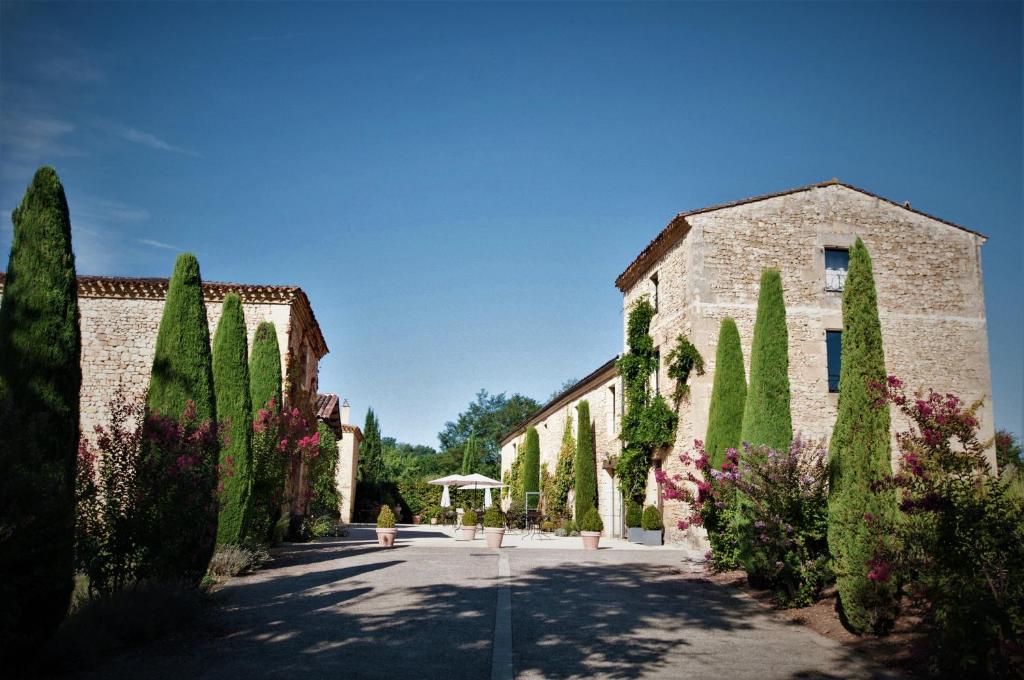 a row of trees in front of a building at Hôtel La Villa Romaine in Carsac-Aillac