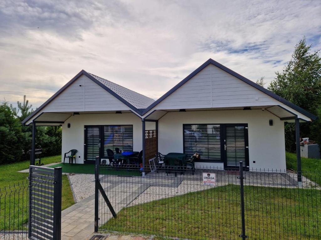 een huis met een hek ervoor bij Domki Paradise 700m od morza !!! in Jarosławiec