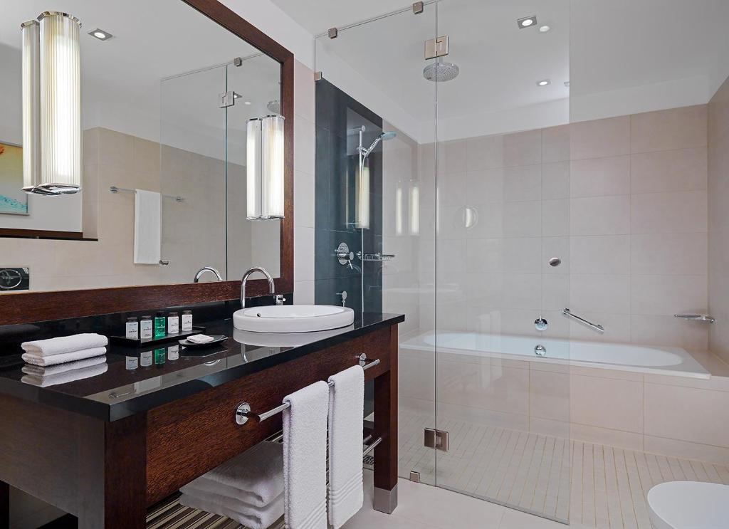 a bathroom with a sink and a shower and a tub at Sheraton Sopot Hotel in Sopot