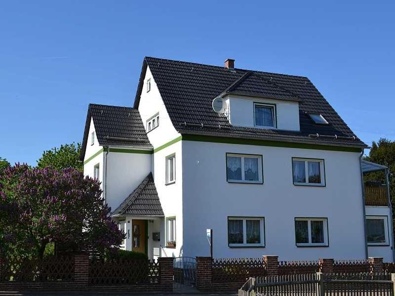 a large white house with a black roof at Ferienwohnung Kalecinski in Tautenhain