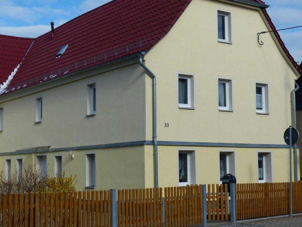 una casa grande con una valla delante en Fewo E33 bei Peter, en Bad Klosterlausnitz