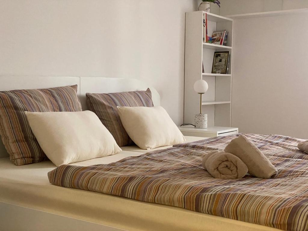 a bed with two pillows on top of it at Apartman Lux 5- private parking in Sombor