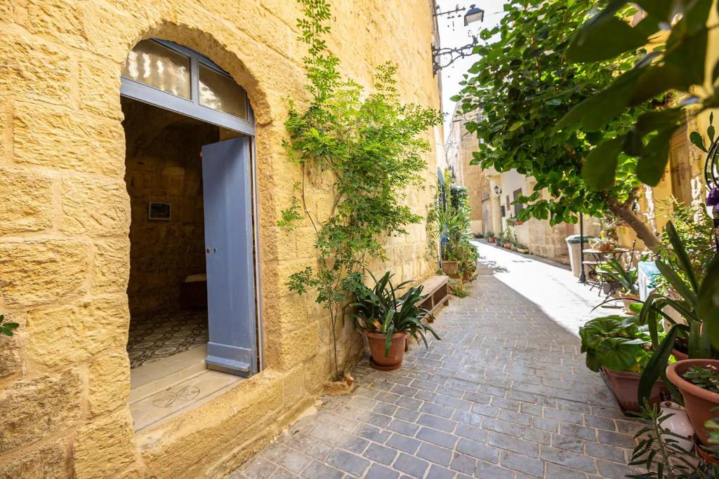 an alley with a blue door in a stone building at Historic Hideaways - 900 Year Old Converted Studios in Victoria