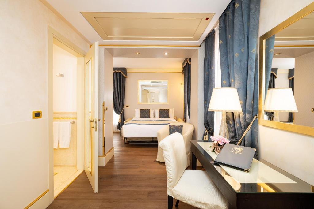 a hotel room with a bed and a desk with a laptop at Hotel A La Commedia in Venice