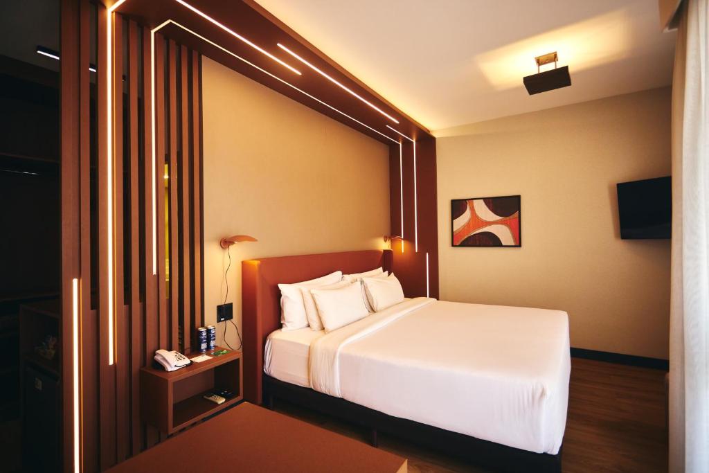 um quarto de hotel com uma cama branca e uma janela em Quality Paulista (São Paulo, Jardins) em São Paulo