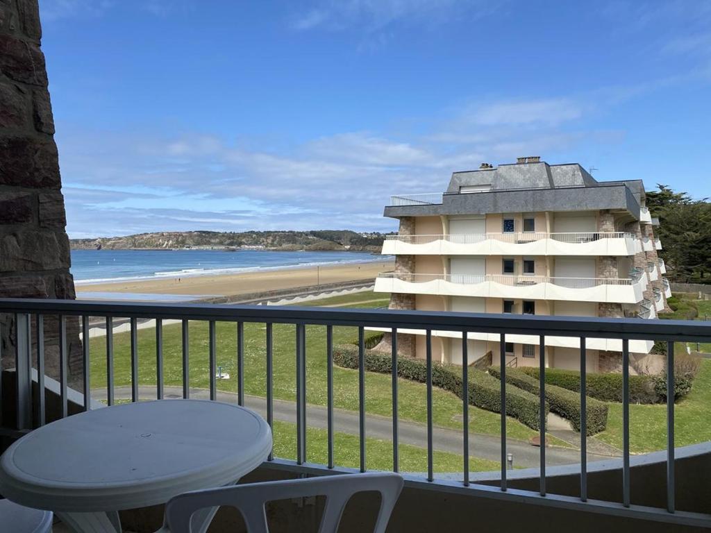 - un balcon avec vue sur un bâtiment et la plage dans l'établissement 441 - A ERQUY, en bordure de la très belle plage de CAROUAL 2km de sables fin, à Erquy