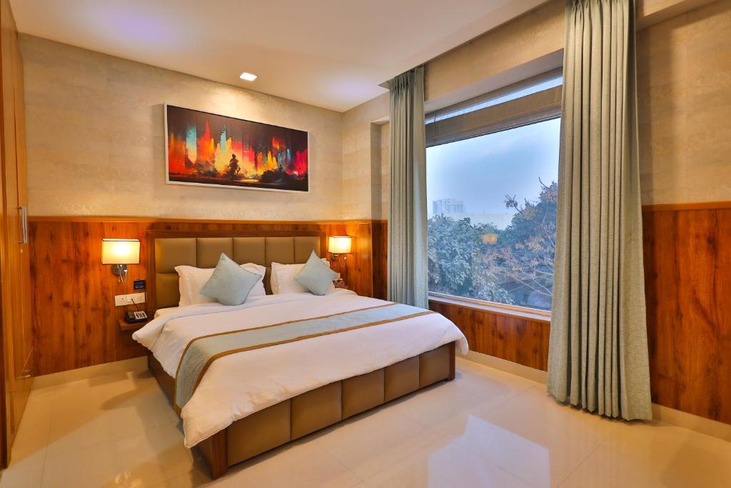 1 dormitorio con cama grande y ventana grande en Clay Inn Hotel, Sohna Road, Sector 49, Gurugram, en Gurgaon
