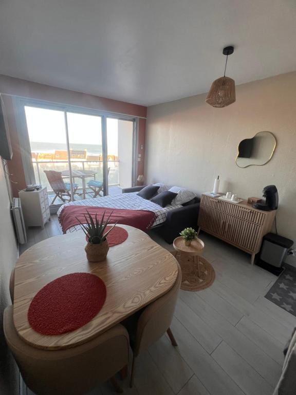 a living room with a couch and a table at Studio Le Mer'Veilleux in Calais