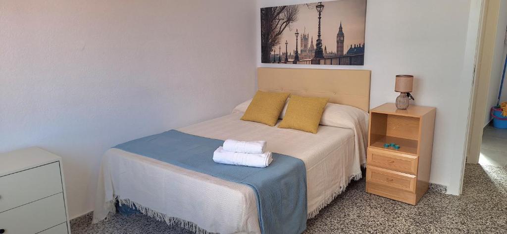 - une petite chambre avec un lit et des oreillers jaunes dans l'établissement La Cantora, à Sagonte