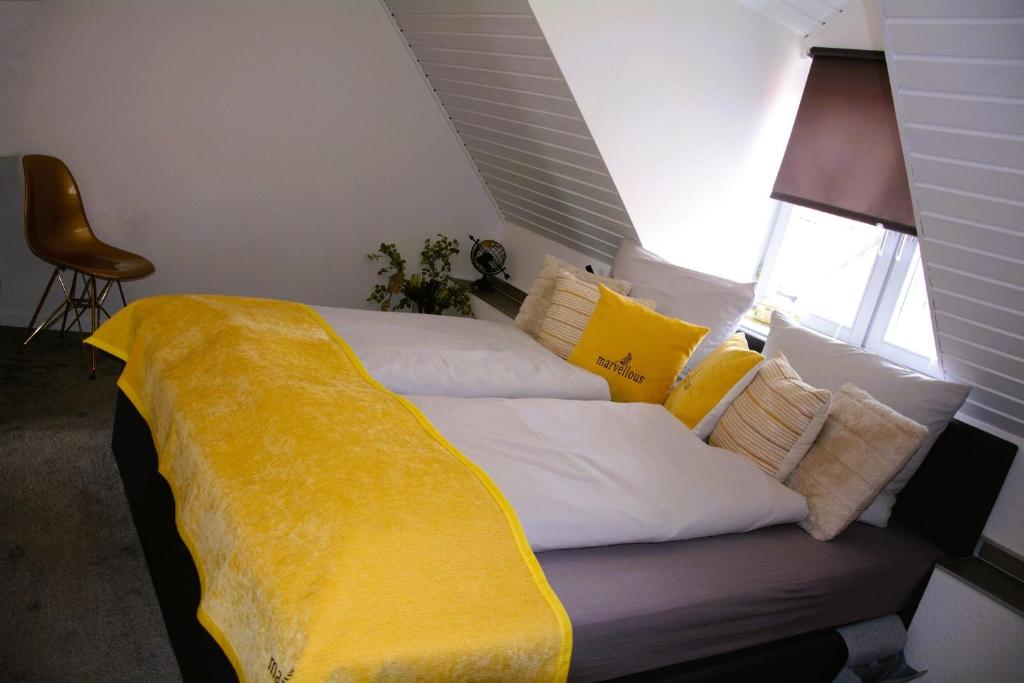 uma cama com um cobertor amarelo em cima em Rosenwinkel Maisonettewohnung DG em Halberstadt