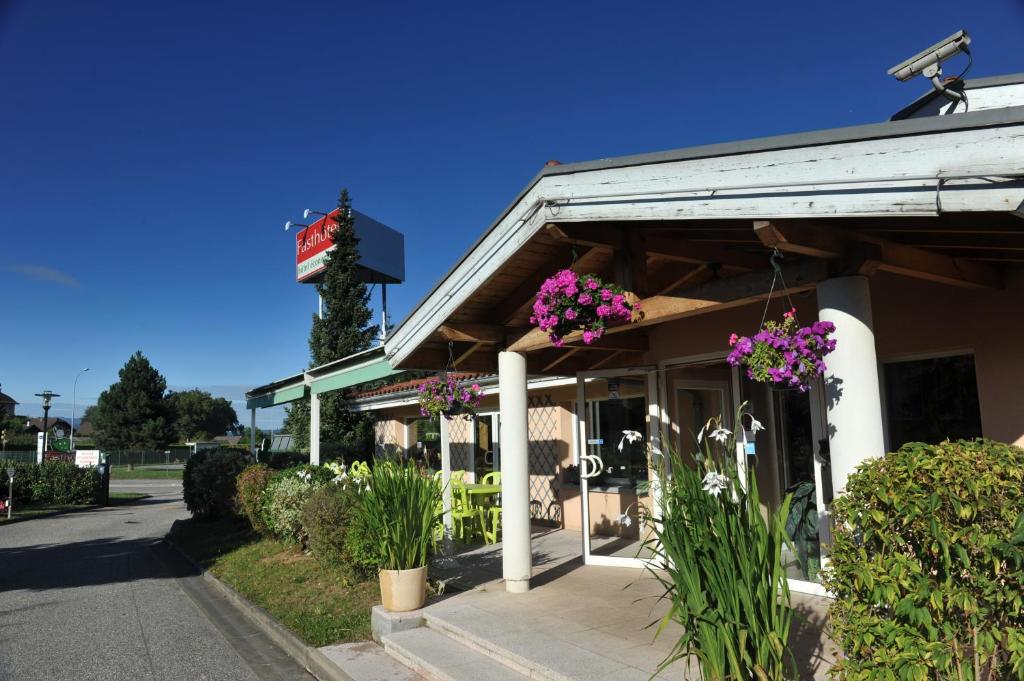 un restaurante con flores púrpuras en la parte delantera en Fasthotel Annecy en Seynod