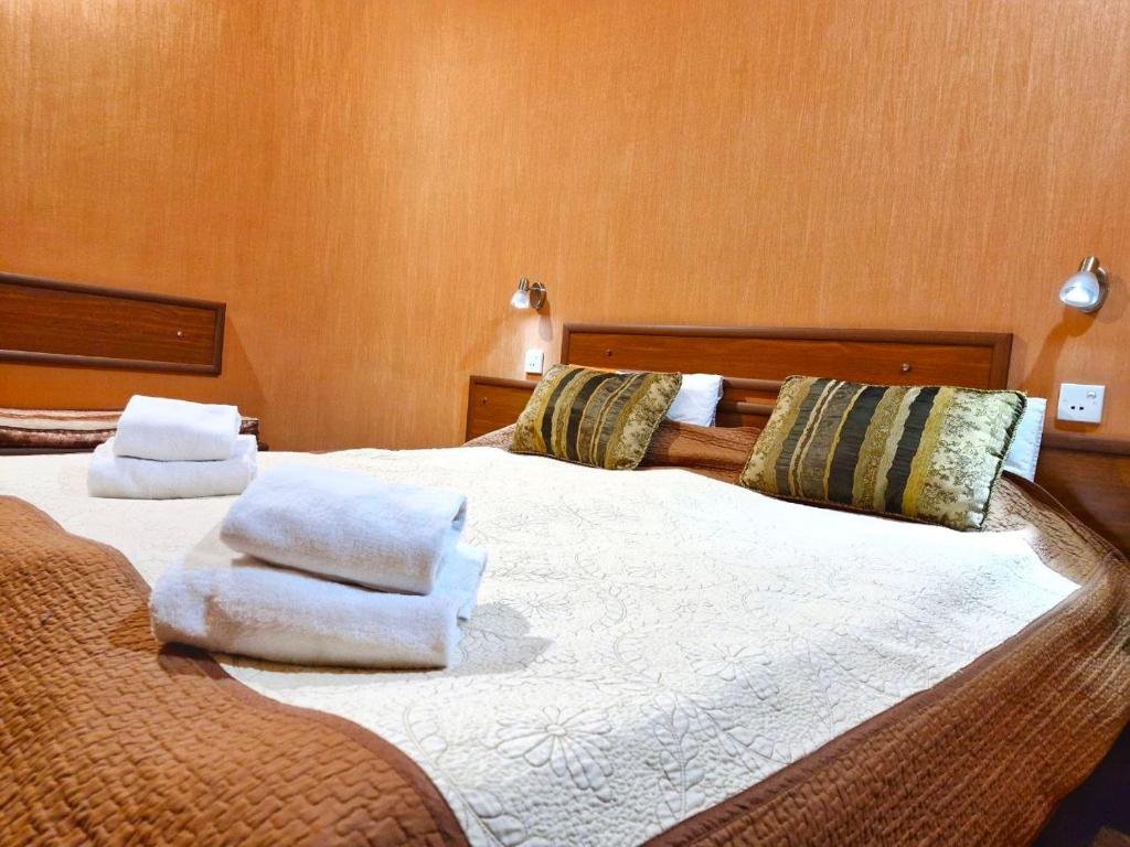 een slaapkamer met 2 bedden en handdoeken bij Hotel Pavo in Tbilisi City