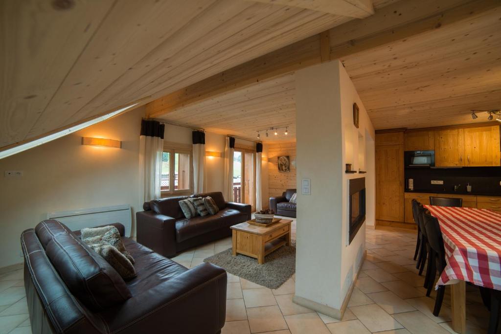 ein Wohnzimmer mit einem Sofa und einem Tisch in der Unterkunft Les Azalées 7 in Les Gets