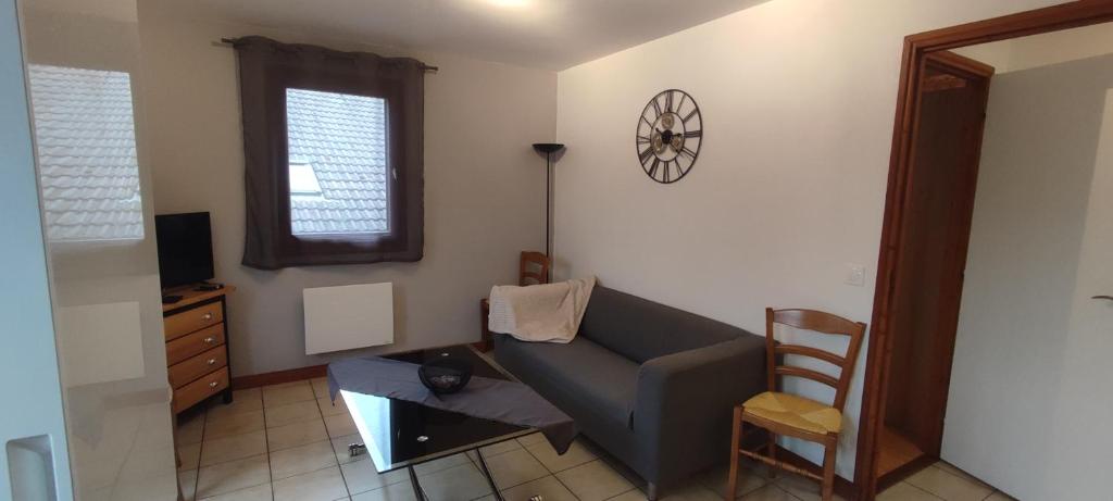 ein Wohnzimmer mit einem Sofa und einem Stuhl in der Unterkunft La Chamade in Le Biot