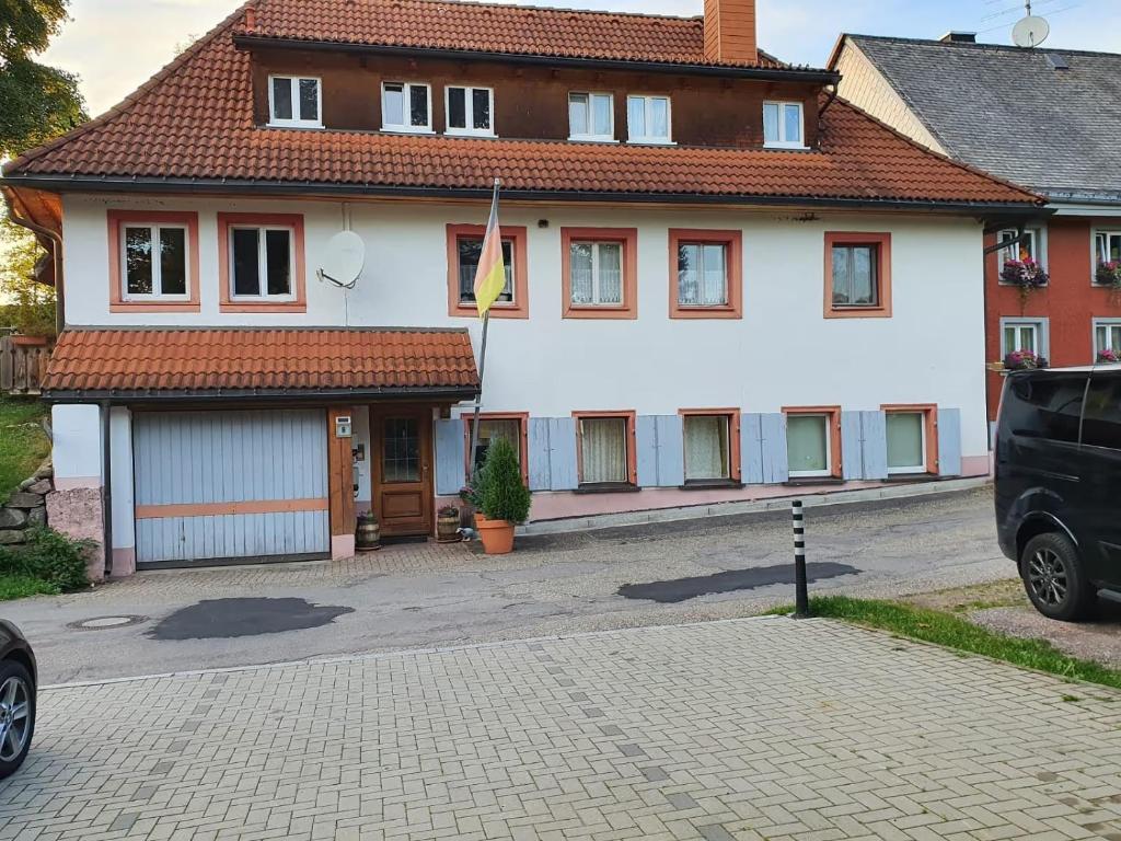 a white house with a parking lot in front of it at Am Bächle in Lenzkirch