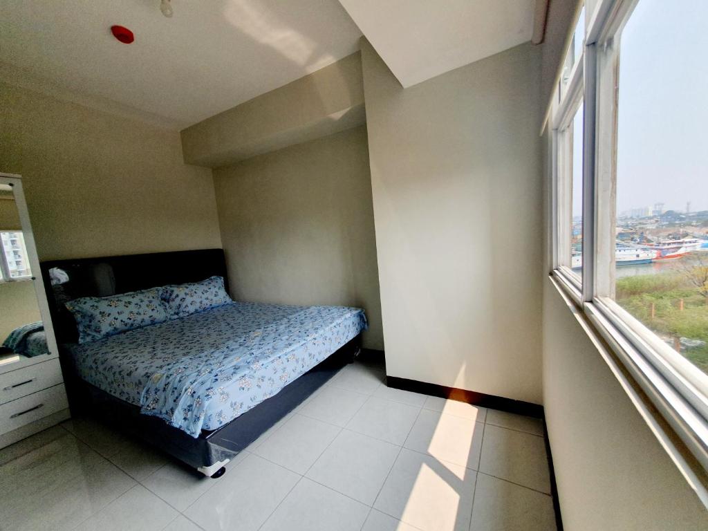 niewielka sypialnia z łóżkiem i oknem w obiekcie Sunda Kelapa View PSV Belize w Dżakarcie