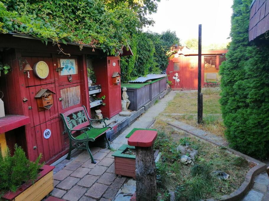 a garden with a bench and a red shed at Gesamtes Haus mit Garten - 100% Privatsphäre in Vienna