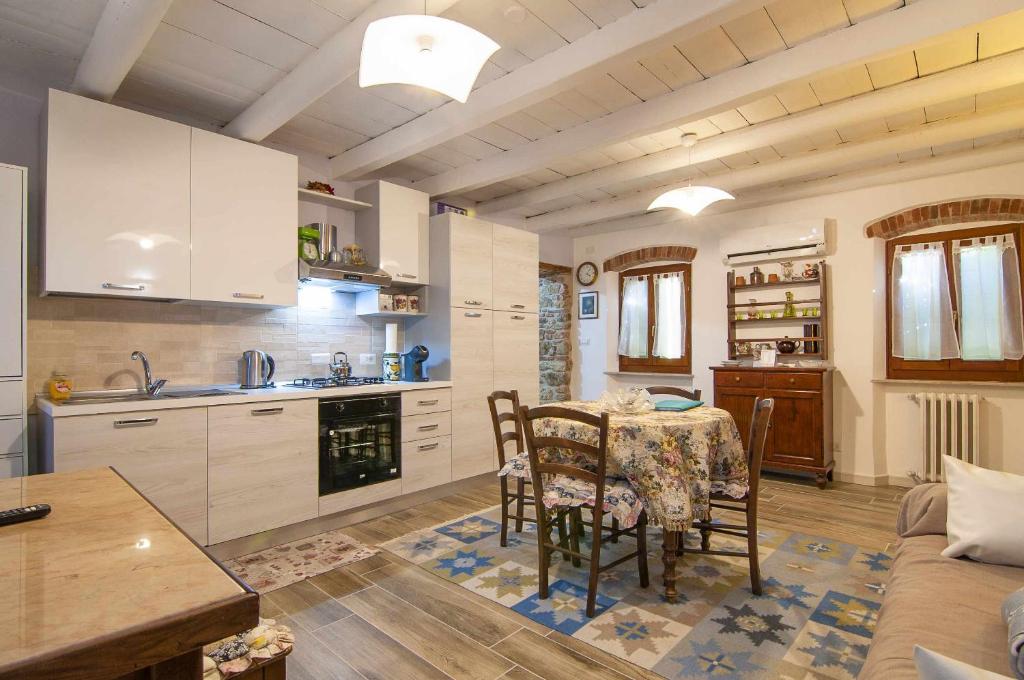 cocina y sala de estar con mesa y sofá en Dimora Montelago Apartment Gino, en SantʼAmbrogio di Valpolicella