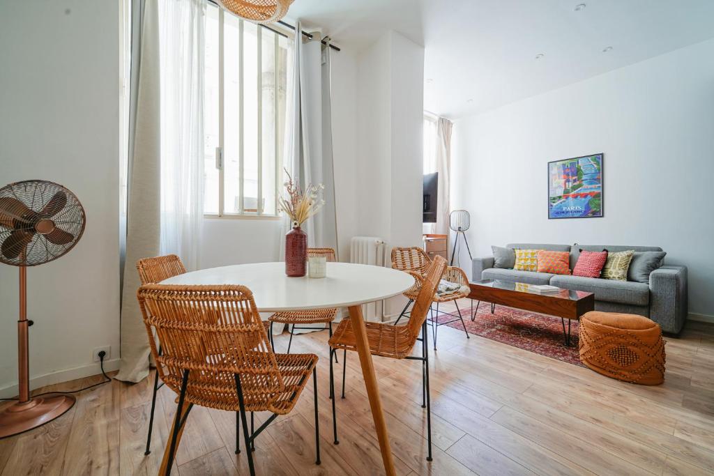 un salon avec une table, des chaises et un canapé dans l'établissement Parisuites Central Canal Saint Martin Design & Luxe & Cosy, à Paris