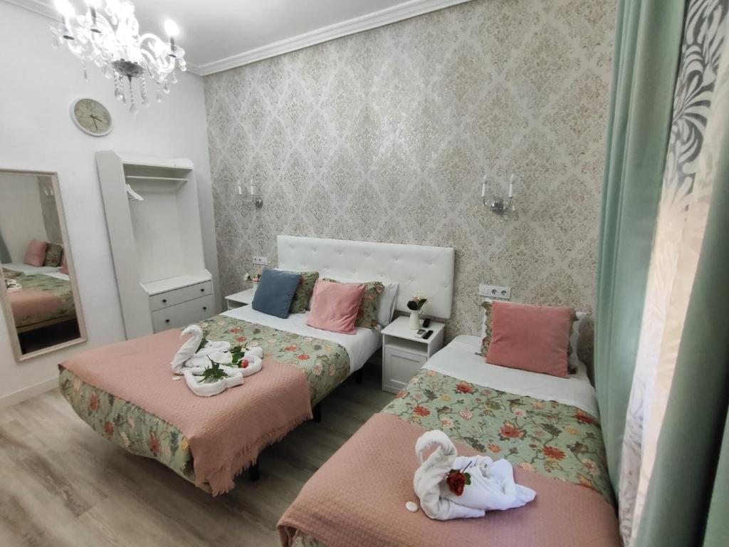 a bedroom with two beds with dolls on them at Hostal Milan in Madrid