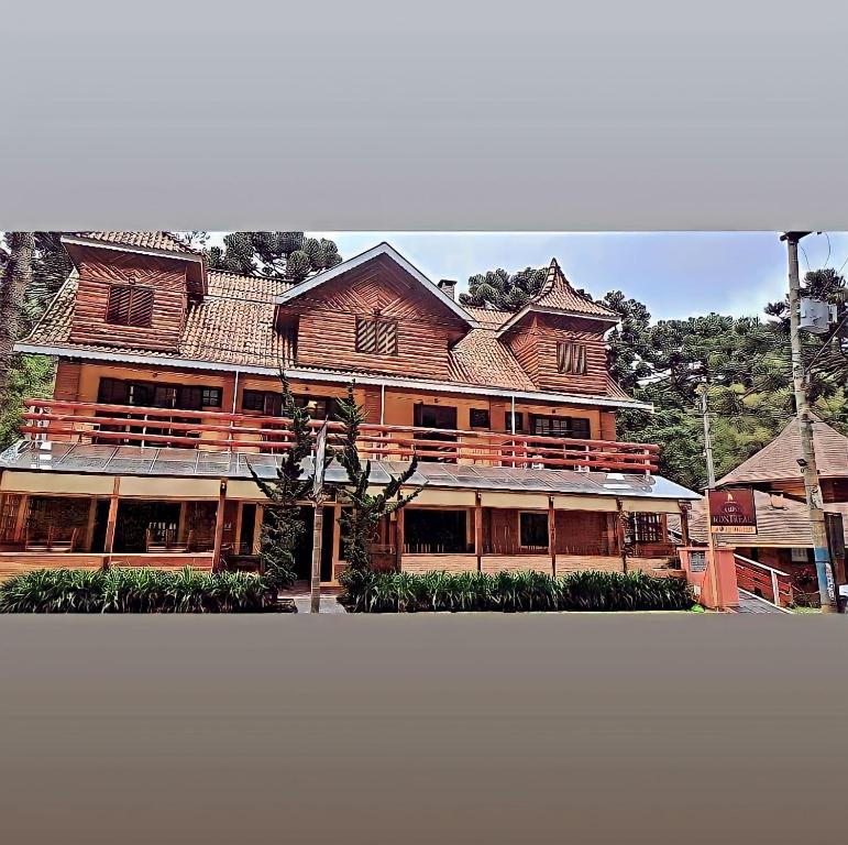 a large wooden building with a large at Pousada Campos Montreal in Campos do Jordão