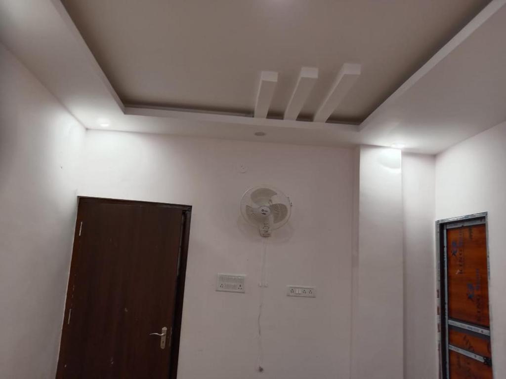 a room with a ceiling with a fan and a door at HOTEL PRW RESIDENCY in Motīhāri