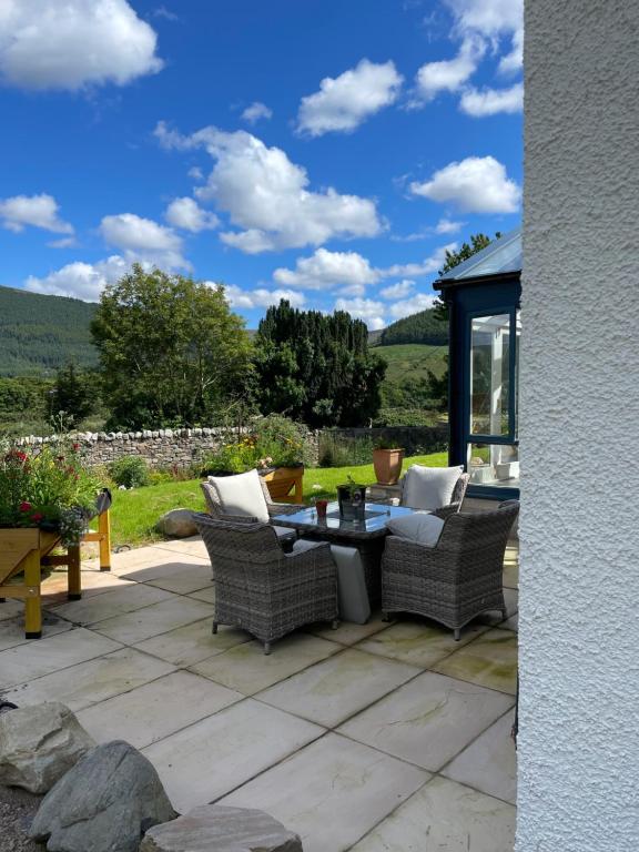 a patio with wicker chairs and a table on a patio at Clachan Garden B&B in Garve