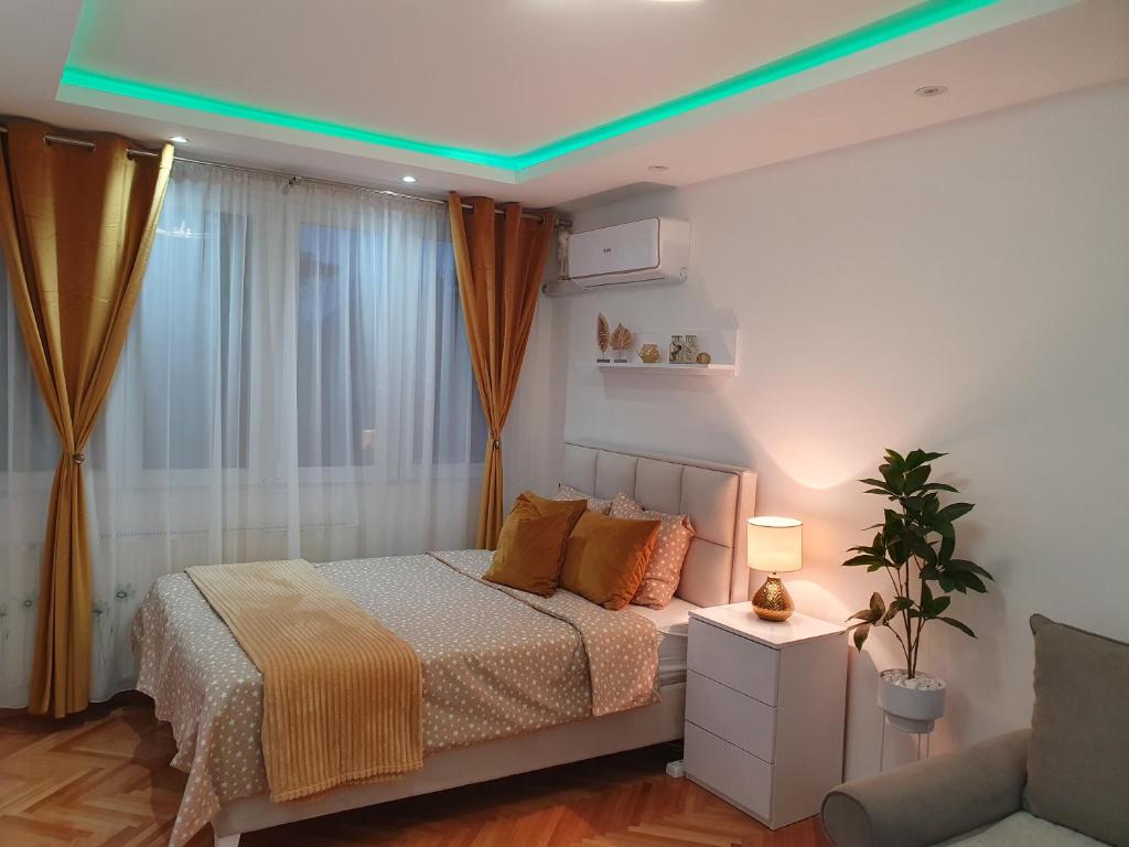 - une chambre dotée d'un lit avec une lumière verte dans l'établissement Stan na dan Golden apartman, à Zaječar
