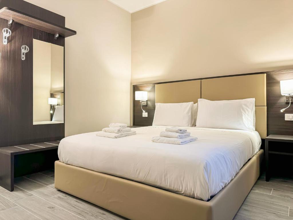 - une chambre avec un grand lit et des serviettes dans l'établissement Brain Harmony Pagani, à Pagani
