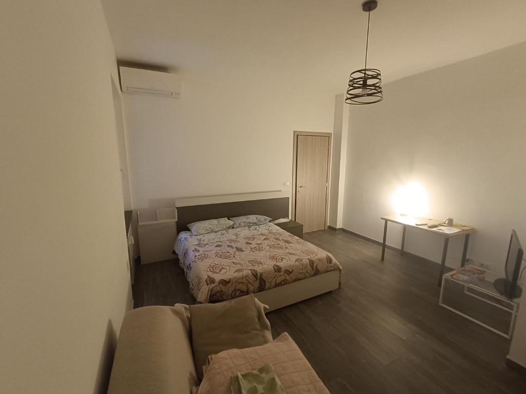 1 dormitorio con 2 camas y sofá en Wake'n Bake Affittacamere en Génova