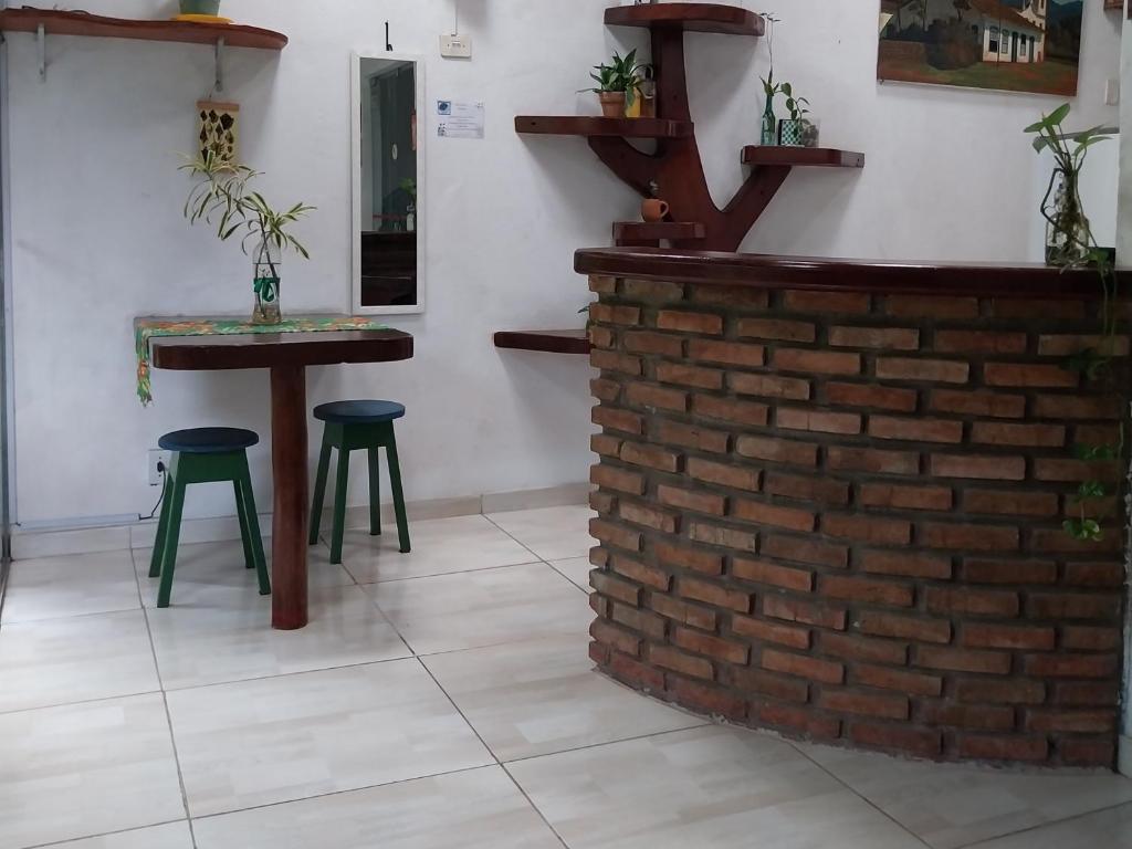 a bar with two stools and a brick wall at Pousada Maravilha Itacaré in Itacaré