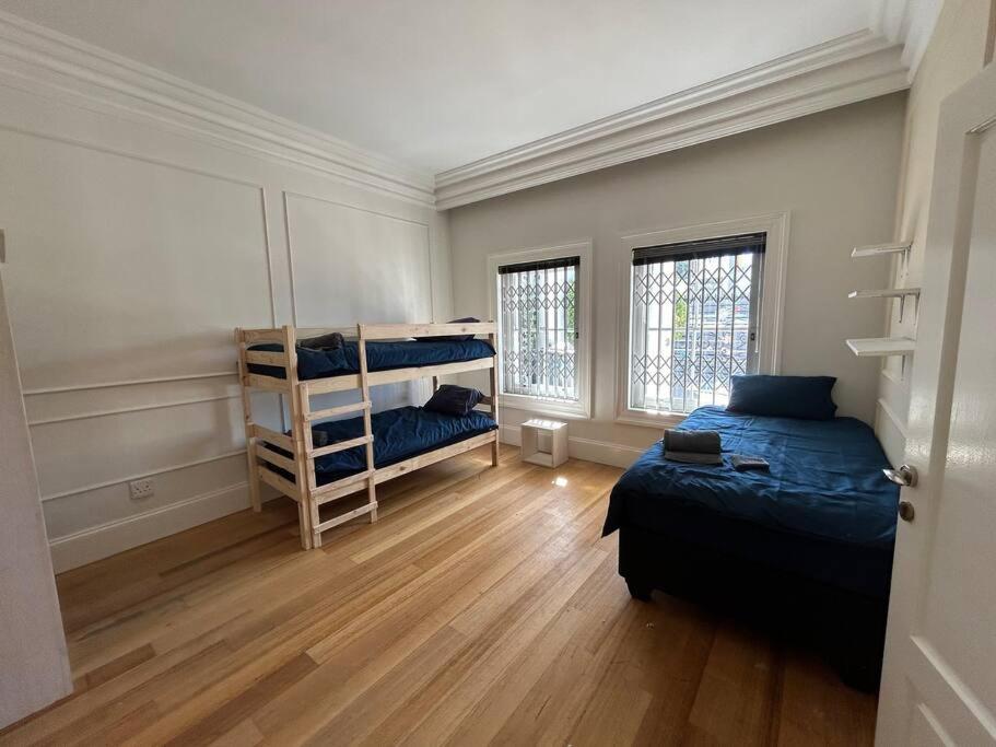 Cape Town的住宿－The Yellow House，一间卧室设有两张床,铺有木地板