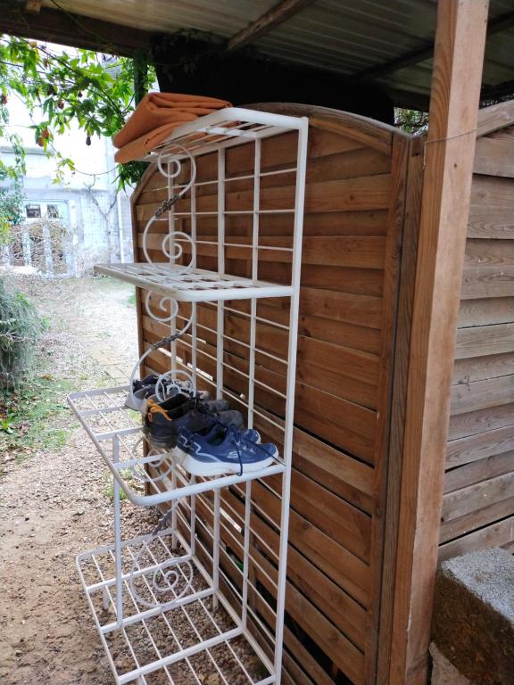 a white shelf next to a wooden wall with shoes at Les Balcons sur la Loire in Chalonnes-sur-Loire