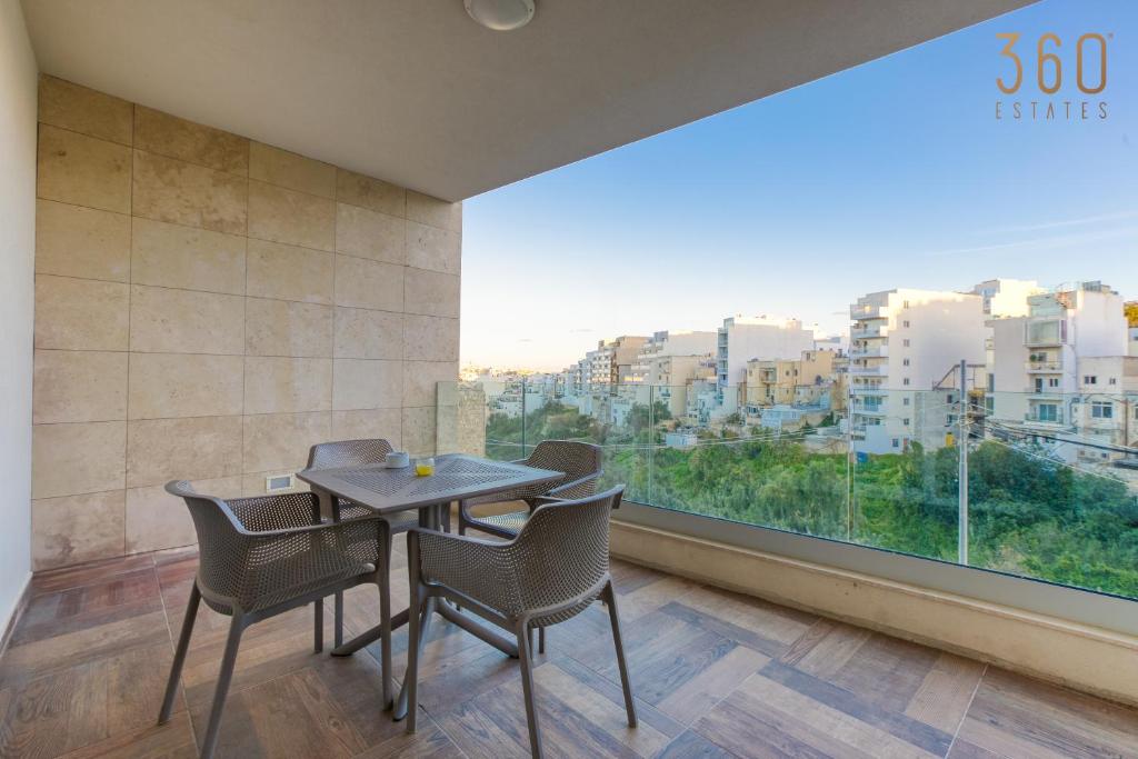 uma sala de jantar com mesa e cadeiras e uma grande janela em Luxury 3BR home in St Julians with private terrace by 360 Estates em Taʼ Ċikkun