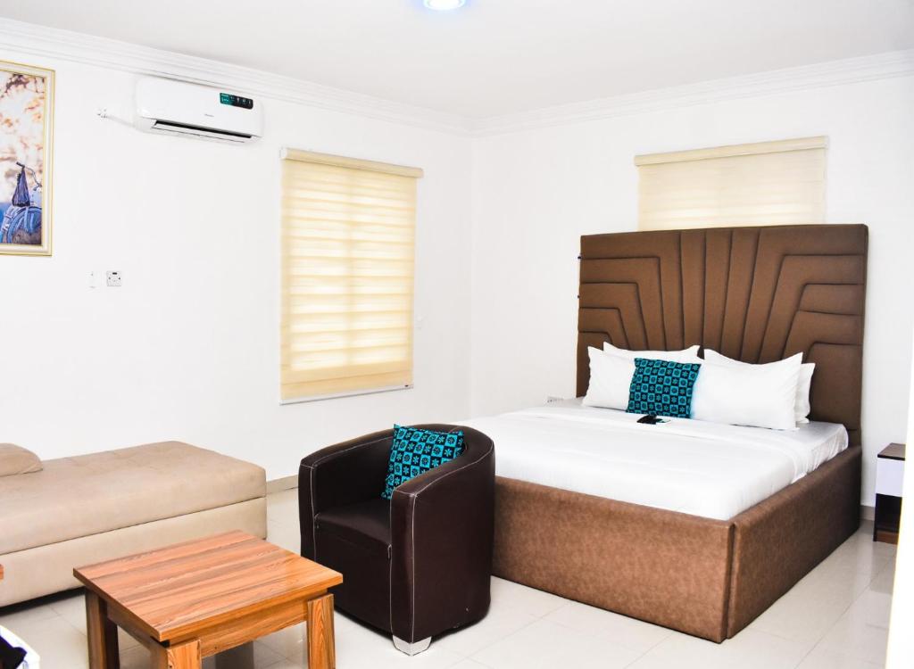 a hotel room with a bed and a chair at Vintage Classic Suites in Lagos