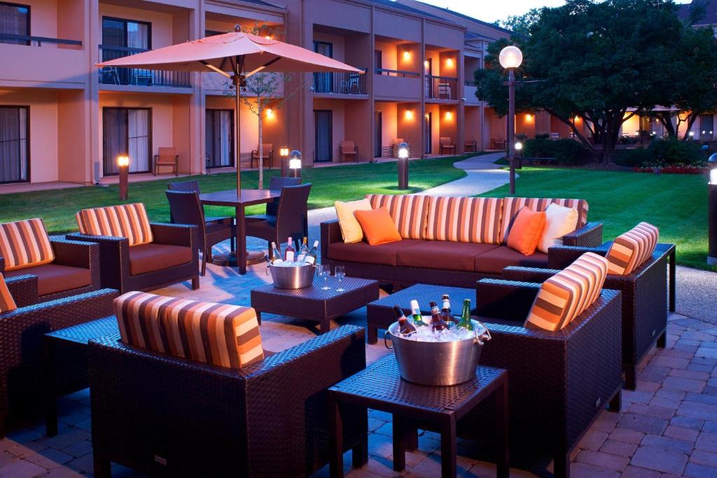 a patio with couches and tables and an umbrella at Courtyard Chicago Arlington Heights/South in Arlington Heights