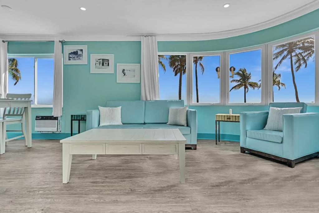 a living room with a blue couch and two chairs at Panoramic beachfront Suite in Hollywood
