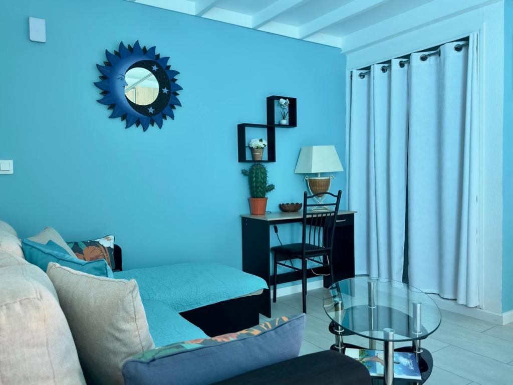 a blue living room with a couch and a table at Sun Caraibes in Orient Bay